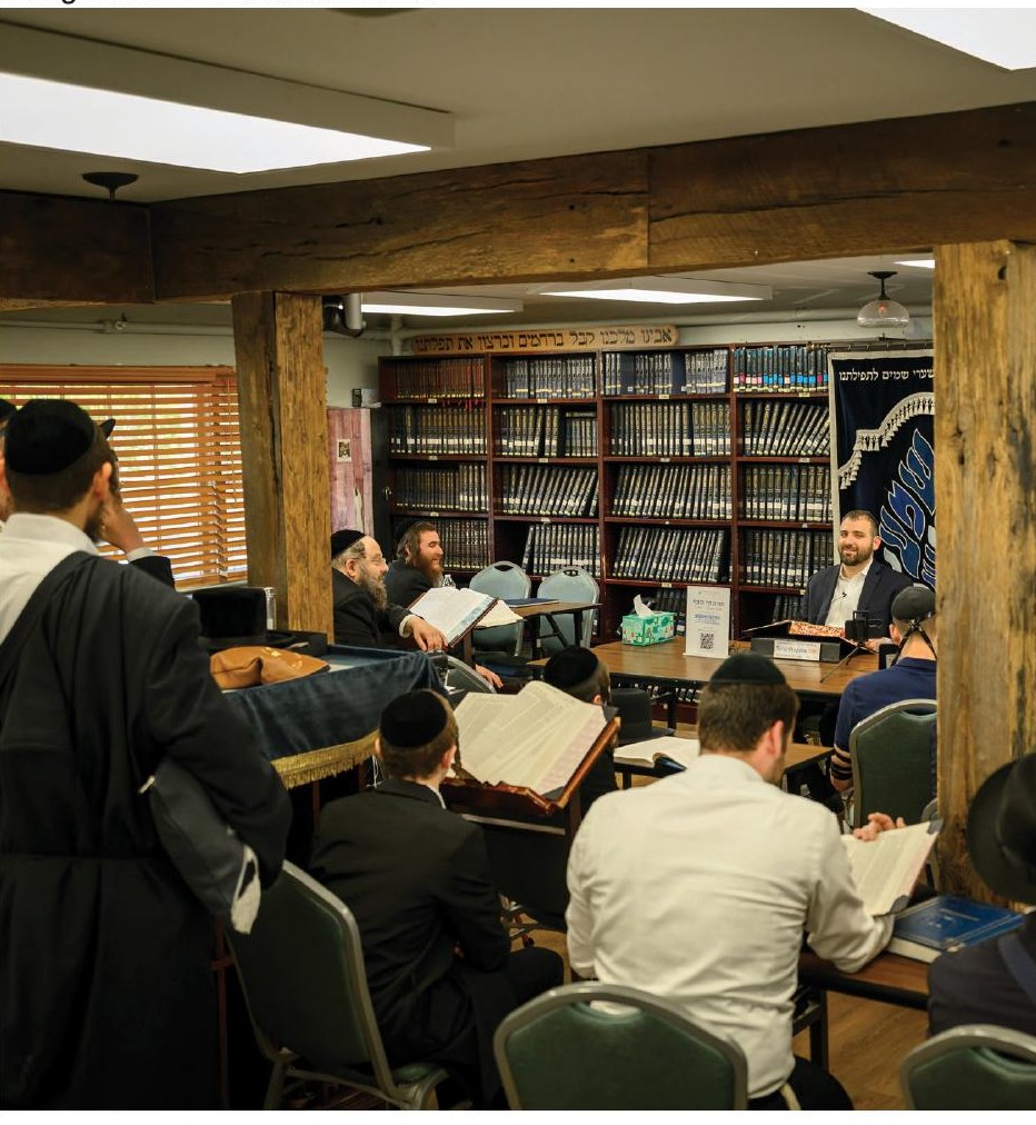 Leo Spitz delivering a shiur to a full beis midrash