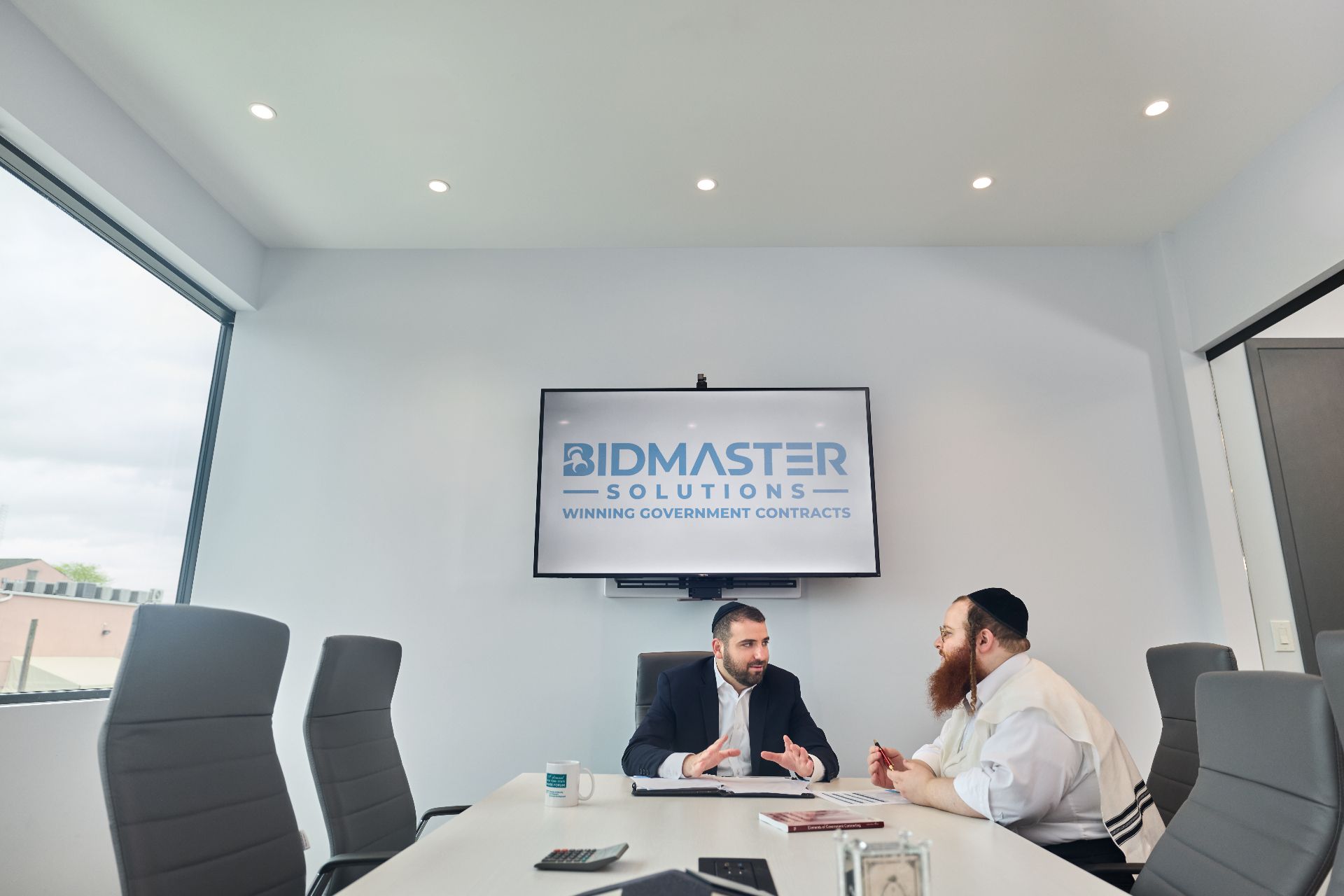 Leo Spitz inside the BidMaster Solutions conference room, leading a working session on government contracting